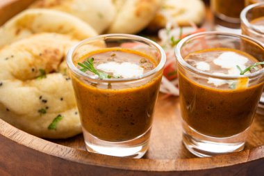 Dal Makhani veya dal Makhni Shots with Naan böbrek fasülyesi, tereyağı ve krema ve sarımsaklı naan veya Hint ekmeği veya roti ile servis edilir.