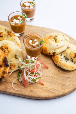 Dal Makhani veya dal Makhni Shots with Naan böbrek fasülyesi, tereyağı ve krema ve sarımsaklı naan veya Hint ekmeği veya roti ile servis edilir.