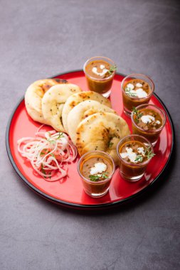 Dal Makhani veya dal Makhni Shots with Naan böbrek fasülyesi, tereyağı ve krema ve sarımsaklı naan veya Hint ekmeği veya roti ile servis edilir.