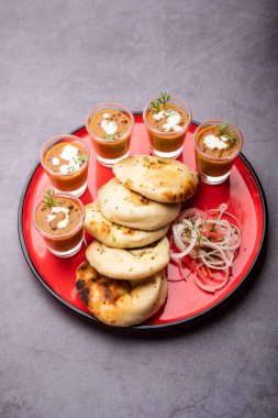 Dal Makhani veya dal Makhni Shots with Naan böbrek fasülyesi, tereyağı ve krema ve sarımsaklı naan veya Hint ekmeği veya roti ile servis edilir.
