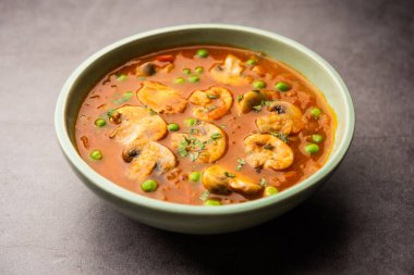 Kızarmış sarımsaklı mantar ve bezelye körisi, Hint yemeği kasede servis edilir.