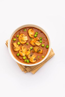 Kızarmış sarımsaklı mantar ve bezelye körisi, Hint yemeği kasede servis edilir.