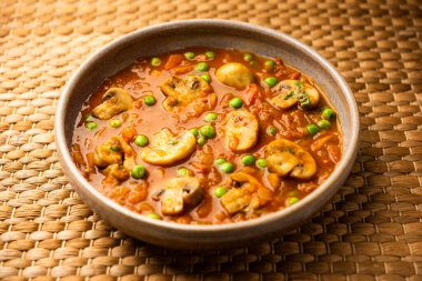 Mushroom and Pea Curry with Roasted Garlic, Indian food served in a bowl