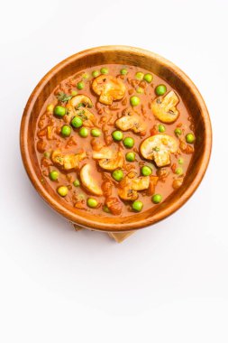 Kızarmış sarımsaklı mantar ve bezelye körisi, Hint yemeği kasede servis edilir.