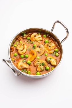 Kızarmış sarımsaklı mantar ve bezelye körisi, Hint yemeği kasede servis edilir.