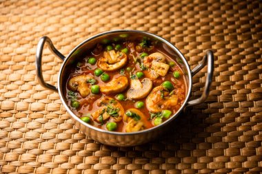 Mushroom and Pea Curry with Roasted Garlic, Indian food served in a bowl
