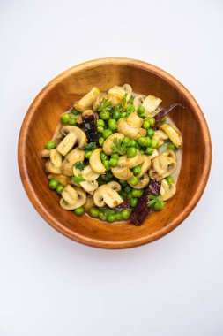 Kızarmış sarımsaklı mantar ve bezelye körisi, Hint yemeği kasede servis edilir.