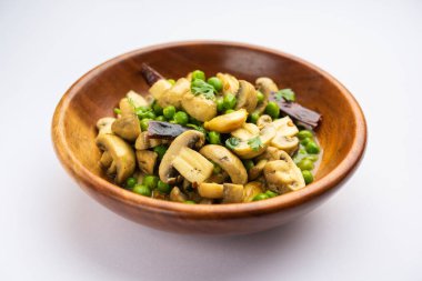 Kızarmış sarımsaklı mantar ve bezelye körisi, Hint yemeği kasede servis edilir.