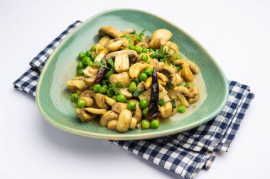 Kızarmış sarımsaklı mantar ve bezelye körisi, Hint yemeği kasede servis edilir.