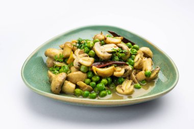 Kızarmış sarımsaklı mantar ve bezelye körisi, Hint yemeği kasede servis edilir.