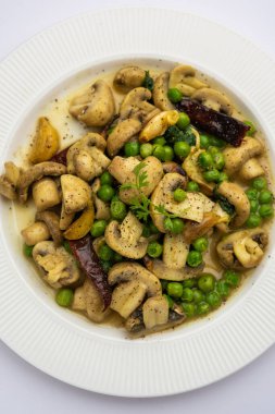 Kızarmış sarımsaklı mantar ve bezelye körisi, Hint yemeği kasede servis edilir.