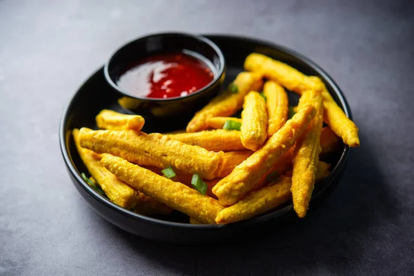 Crispy fried baby corn pakoda, pakora  or Baby corn fritters served with ketchup, Indian food