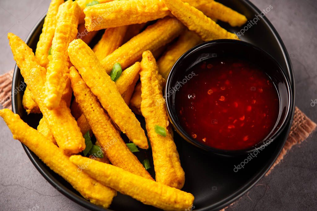Crispy fried baby corn pakoda, pakora or Baby corn fritters served with
