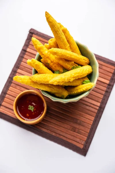 Crispy fried baby corn pakoda, pakora  or Baby corn fritters served with ketchup, Indian food