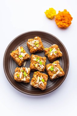 Dodha Barfi or Doda Burfi is a traditional Indian sweet, which has a grainy and chewy texture clipart