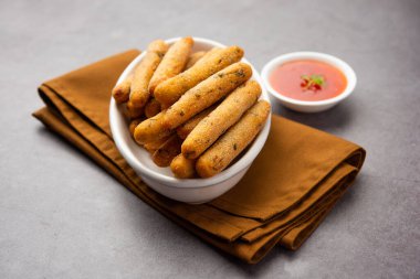 crispy Rava Aloo fingers or Potato semolina fried finger sticks served with ketchup