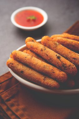 crispy Rava Aloo fingers or Potato semolina fried finger sticks served with ketchup