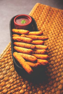 crispy Rava Aloo fingers or Potato semolina fried finger sticks served with ketchup