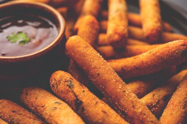 crispy Rava Aloo fingers or Potato semolina fried finger sticks served with ketchup