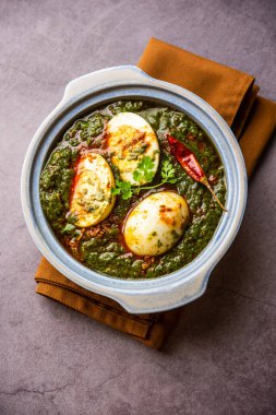 Spinach egg curry is an Indian non vegetarian dish made using palak gravy with eggs