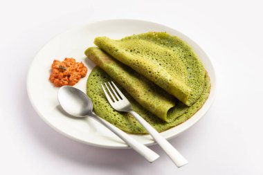 Palak dosa made using mixing spinach or keerai in batter, served with red chutney