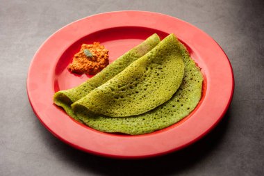 Palak dosa made using mixing spinach or keerai in batter, served with red chutney