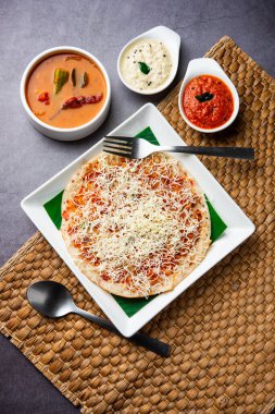 Peynirli uttapam pizza, kıvrımlı Güney Hint yemeği. Sambar ve baharatla servis edilir.