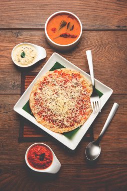 Peynirli uttapam pizza, kıvrımlı Güney Hint yemeği. Sambar ve baharatla servis edilir.