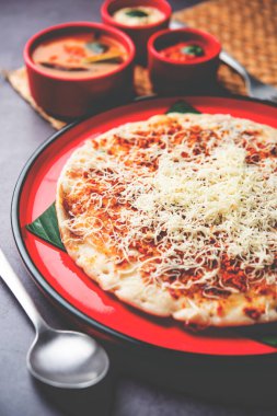 Peynirli uttapam pizza, kıvrımlı Güney Hint yemeği. Sambar ve baharatla servis edilir.
