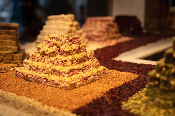 rows of Turkish delight sweets desserts with dried fruits arranged in a pyramid and lined up in the store window