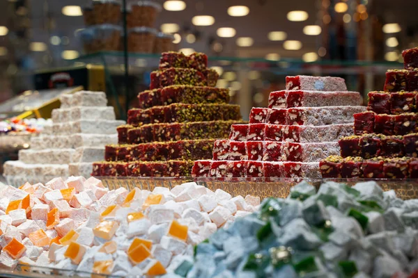 Sıra sıra Türk tatlıları, piramit şeklinde kurutulmuş meyvelerle çeşitlendiriliyor ve mağazanın vitrinine diziliyor