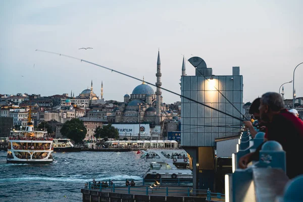 İSTANBUL, TURKEY - 10 AĞUSTOS 2021: Yerel halk gün batımında balık tutmak ve sosyalleşmek için toplanıyor.