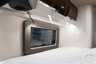 Pencerenin yanındaki yatağın ve karavanın içindeki boş yatak odasındaki depo raflarının yakınına.