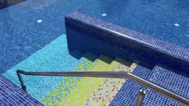 왼쪽은 세라믹 타일로 장식된 수영장에 사다리 난간을 클로즈업 — 비디오