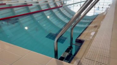 Perspektif görüntüsü, yüzme havuzunda uzanan krom merdiven korkuluklarının yakın çekimi