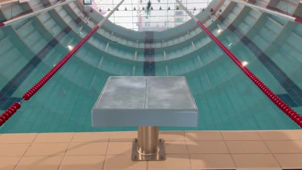 前景特写比赛游泳池比赛的起点块 背景为红道分隔及蓝水 — 图库视频影像