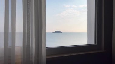 Şeffaf kumaş perdeleri olan küçük bir okyanus adası.