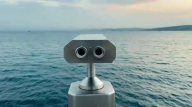 Deniz kıyısında alüminyum metalik dürbün kullanan madeni paranın arka plan görüntüsü