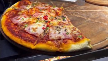 Bakış açısına göre farklı pizza çeşitleri sokak yemekhanesinin vitrinindeki ahşap tabaklarda.