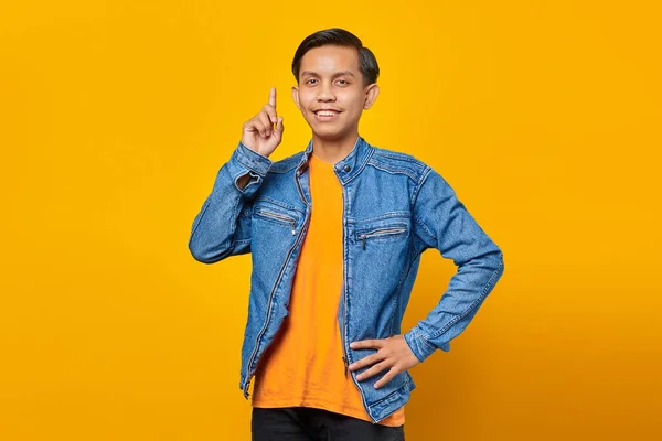 黄色の背景に隔離されたライブ広告プロモーションを指す陽気なアジアの若者の肖像画 — ストック写真