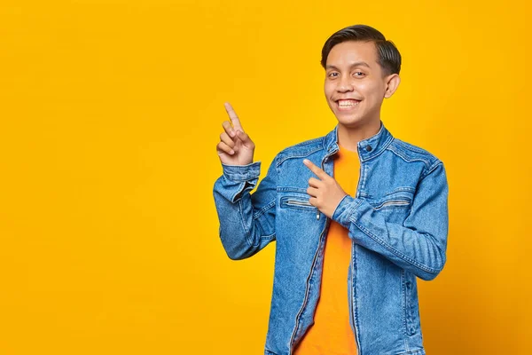 Fröhlicher Junger Asiatischer Mann Zeigt Mit Zwei Fingern Zur Seite — Stockfoto