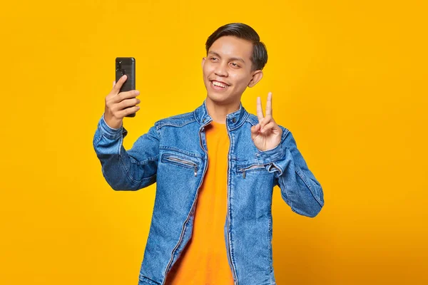 Portret Van Aziatische Man Glimlachend Toont Vrede Teken Terwijl Het — Stockfoto