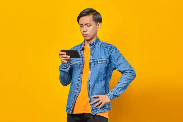 Азіатський Чоловік Використовує Мобільний Телефон Граючи Гру Сердитим Обличчям Жовтому — стокове фото