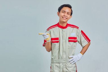 Gülümseyen Asyalı tamircinin portresi parmak ile kopyalama alanını gösteriyor.