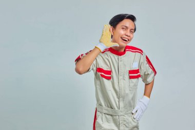 Mekanik üniforma giyen ciddi yakışıklı bir adamın portresi gri arka planda gizli bir konuşmaya kulak misafiri olmaya çalışıyor.