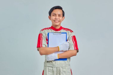 Gri arkaplanda pano gösteren gülümseyen tamircinin portresi