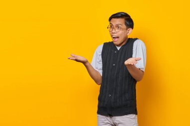 Asyalı adamın portresi sarı arka planda şaşkın ve hoşnutsuz bir ifadeyle şaşırdı.