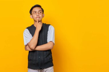 Asyalı bir gencin portresi, eli çenesinde soru sormayı düşünüyor.