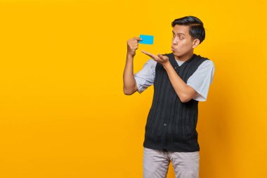 Sarı arka planda izole edilmiş, gülümseyen, yakışıklı, öpüşen genç adamın portresi.