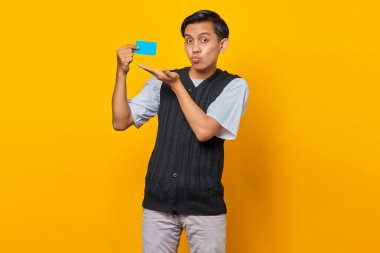 Sarı arka planda izole edilmiş, gülümseyen, yakışıklı, öpüşen genç adamın portresi.